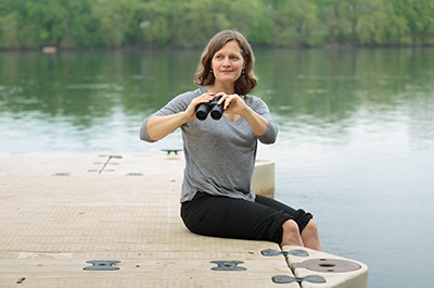 Morgan Benowitz-Fredericks sitting on a dock with binoculars