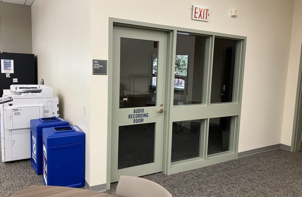 A door labeled "Audio Recording Room" next to some trash cans and a printer