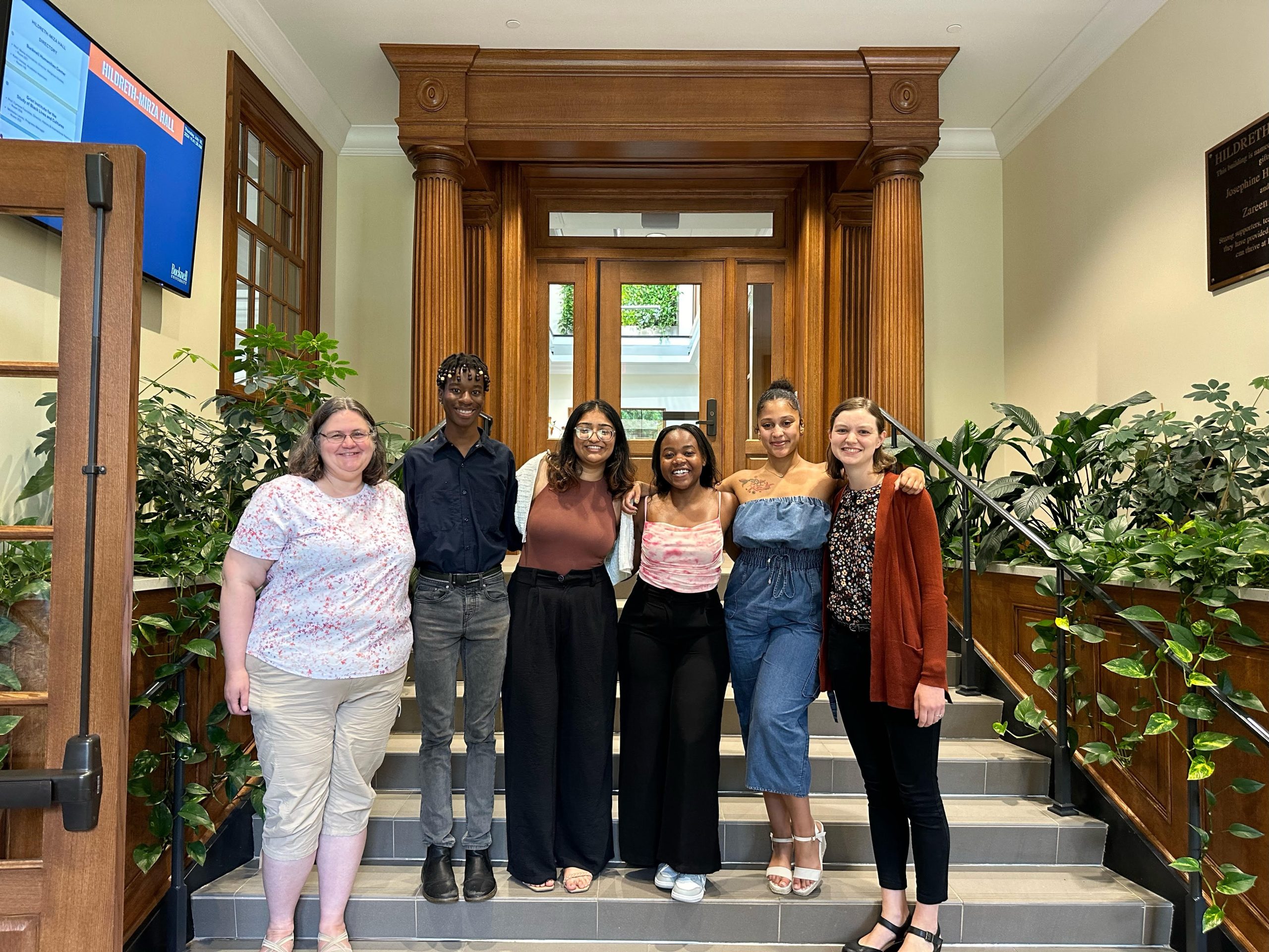 A group photo of the DSSRF cohort and facilitators standing on the steps of the Bucknell Humanities Center (Carrie Pirmann, Thandeka Bango, Malika Ali, Jackline Masetu, Gianna Depina, and Claire Cahoon)